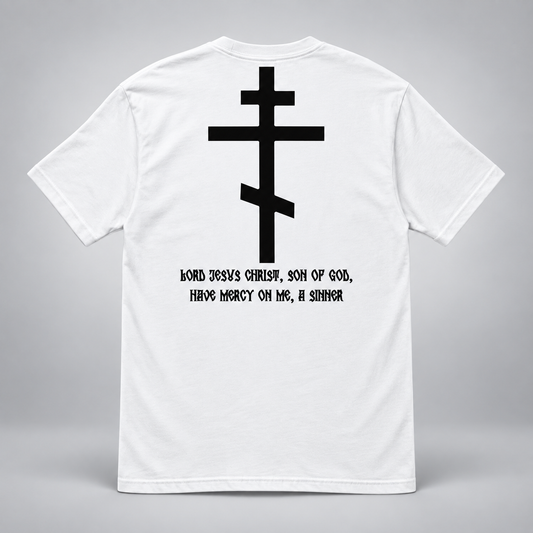 White short-sleeve T-shirt shown from the back on a light gray background, featuring a large black Orthodox cross graphic and the printed text 'JORD JESUS CHRIST, SON OF GOD, HAVE MERCY ON ME, A SINNER' in black.