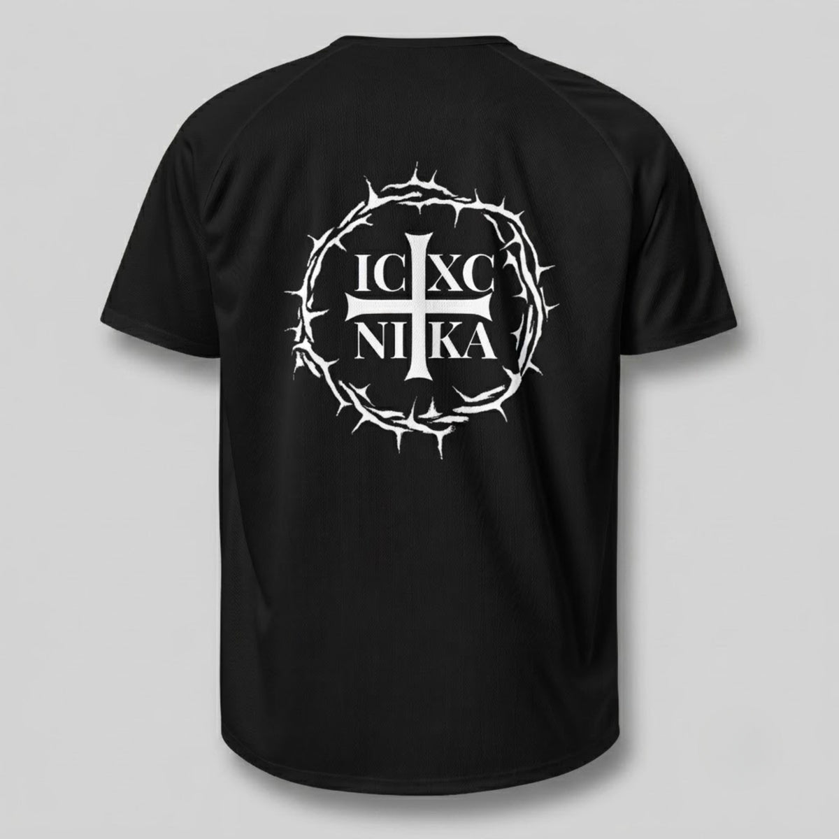 Un tricou negru cu mâneci scurte văzut din spate, cu un imprimeu alb reprezentând o cruce într-o cunună de spini și textul „IC XC NI KA” în centru, pe un fundal gri deschis simplu