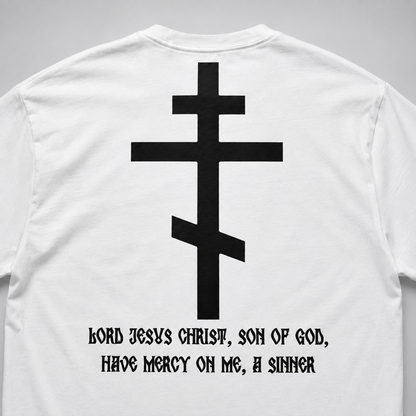 Rückansicht eines weißen Langarm-T-Shirts mit großem schwarzem orthodoxem Kreuzmotiv und gotischer Aufschrift „HERR JESUS CHRISTUS, SOHN GOTTES, ERBARME DICH MEINER, DES SÜNDERS“.