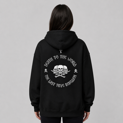 Rückansicht einer Person in schwarzem Pullover-Hoodie mit großem weißem Rückendruck. Das Design zeigt einen Totenkopf mit gekreuzten Knochen inmitten der kreisförmigen Aufschrift „THE LAST TRUE REBELLION“.
