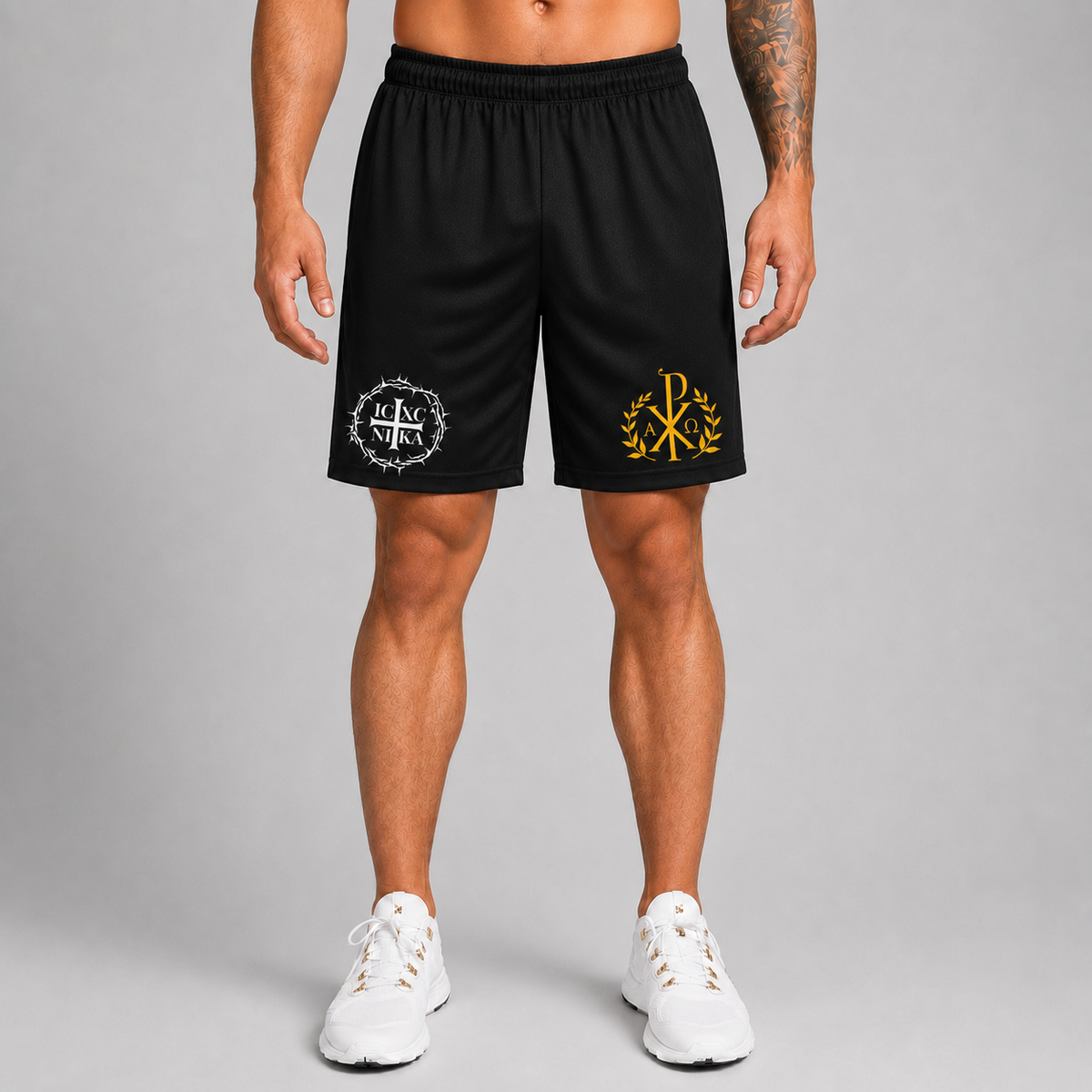 A model from the waist down wearing black athletic shorts with white and gold ogos, paired with white sneakers, against a neutral gray studio background.