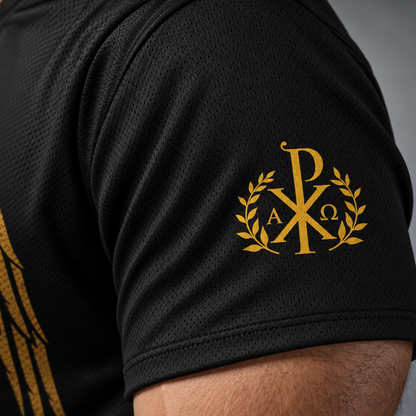 Close-up of a black athletic jersey sleeve featuring a gold monogram crest with laurel branches and a partial gold eagle graphic on the shoulder.
