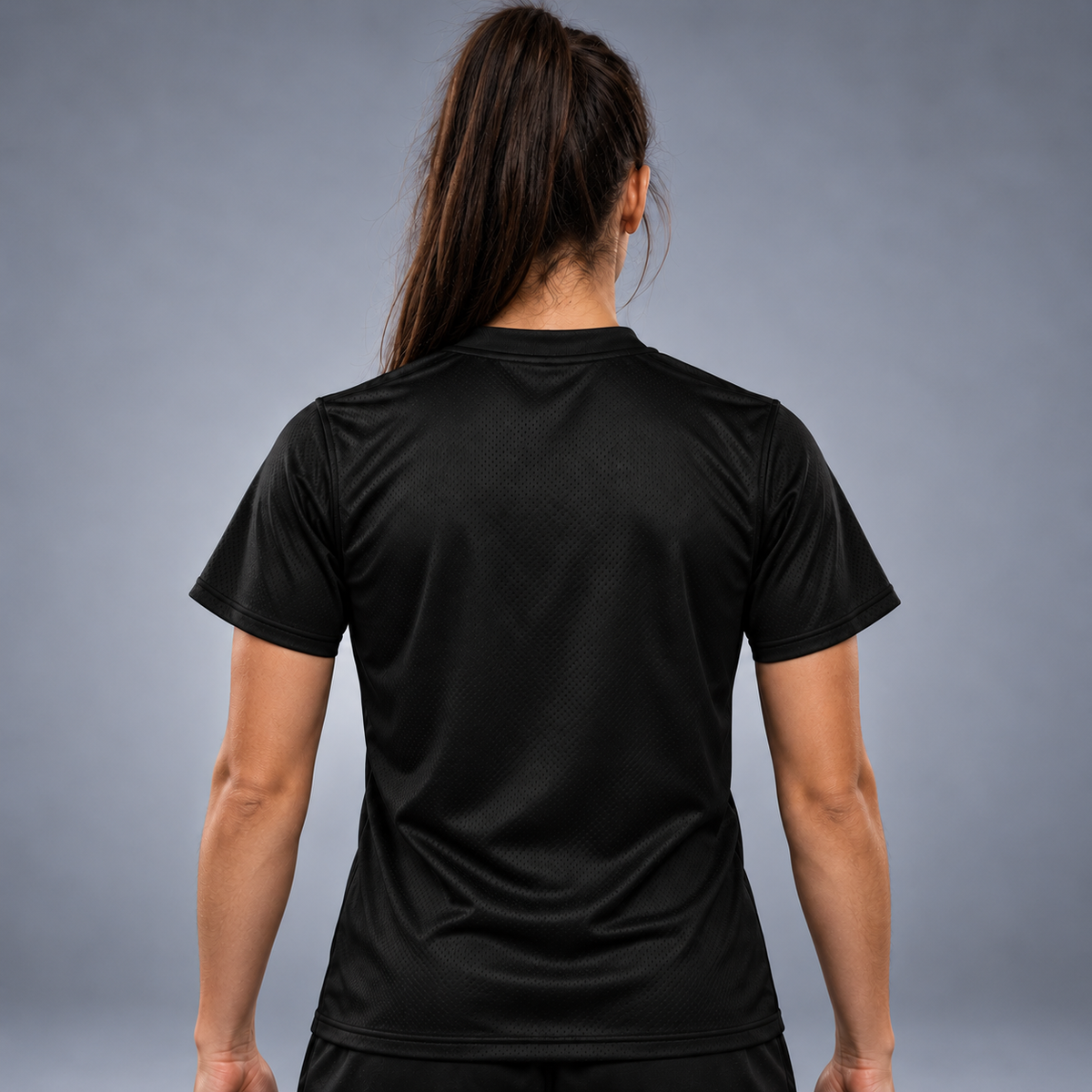 Awoman wearing Black short-sleeve athletic jersey shown from the back, featuring a subtle textured mesh pattern and a crew neck, photographed against a neutral gray studio background.