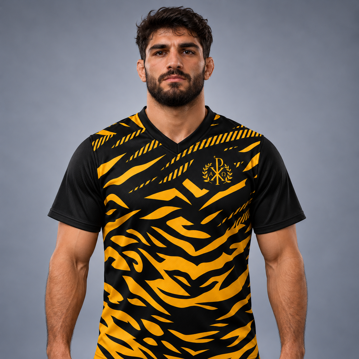 A man wearing A short-sleeve V-neck athletic jersey with a bold black and yellow tiger-stripe pattern, featuring a gold monogram logo on the chest, displayed on a neutral gray background.