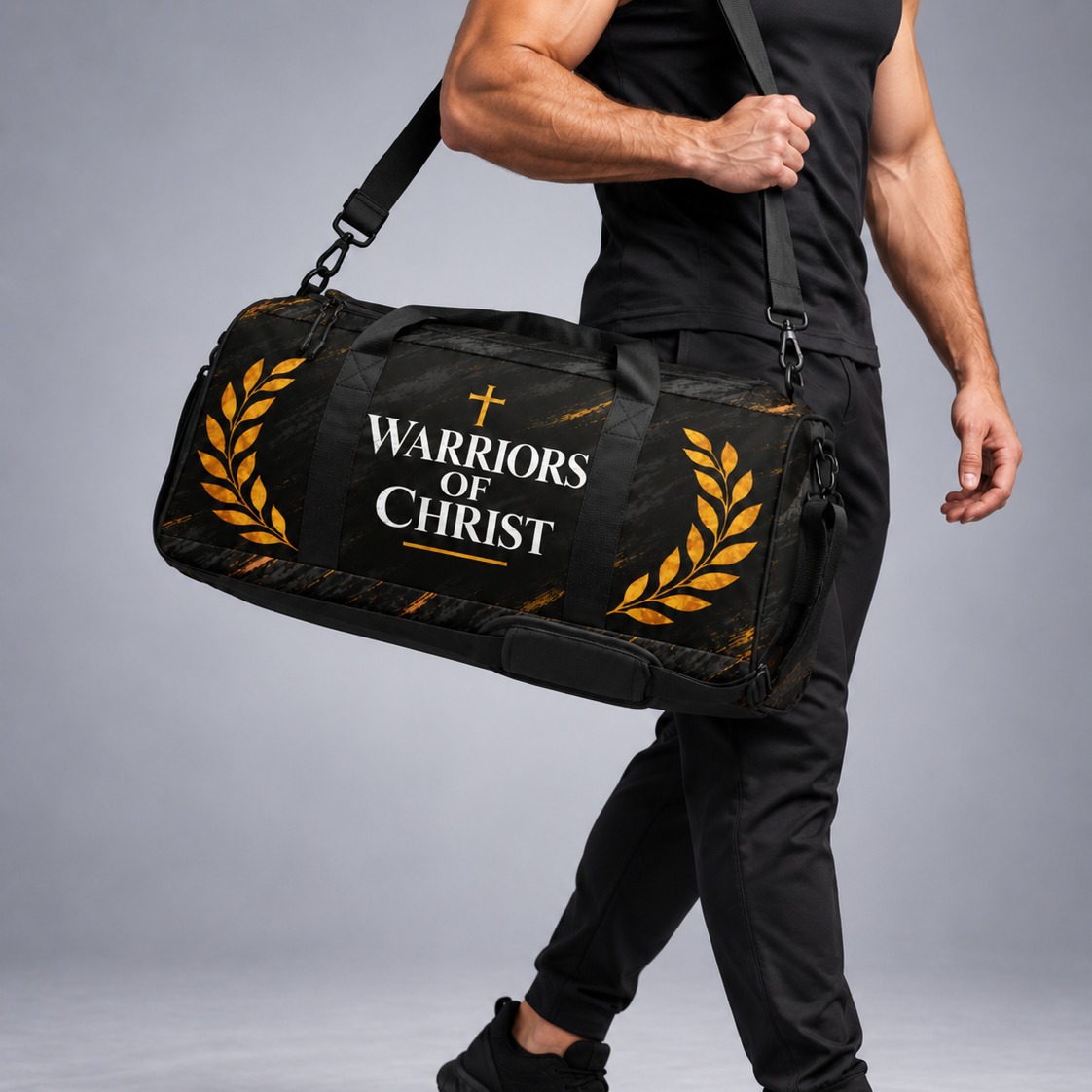 A man in a black athletic outfit carrying a black duffel bag with gold laurel designs and the text 'WARRIORS OF CHRIST' printed on the front, set against a gray studio background.