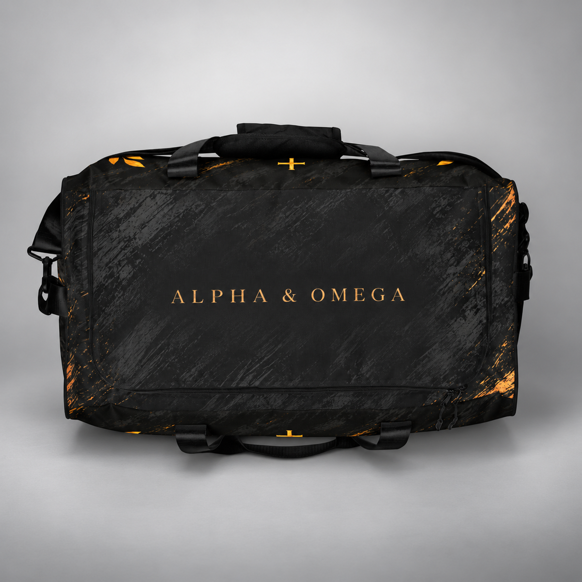 A black duffel bag with gold foil lettering reading 'ALPHA & OMEGA' on the front, set against a neutral gray background.