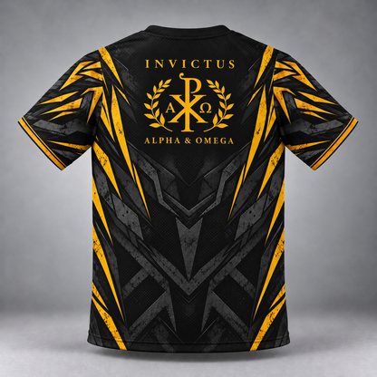 Black short-sleeve t-shirt with a gold and gray geometric graphic design, featuring the text 'INVICTUS ALPHA & OMEGA' and a Chi-Rho emblem on the back, shown against a gray studio background.