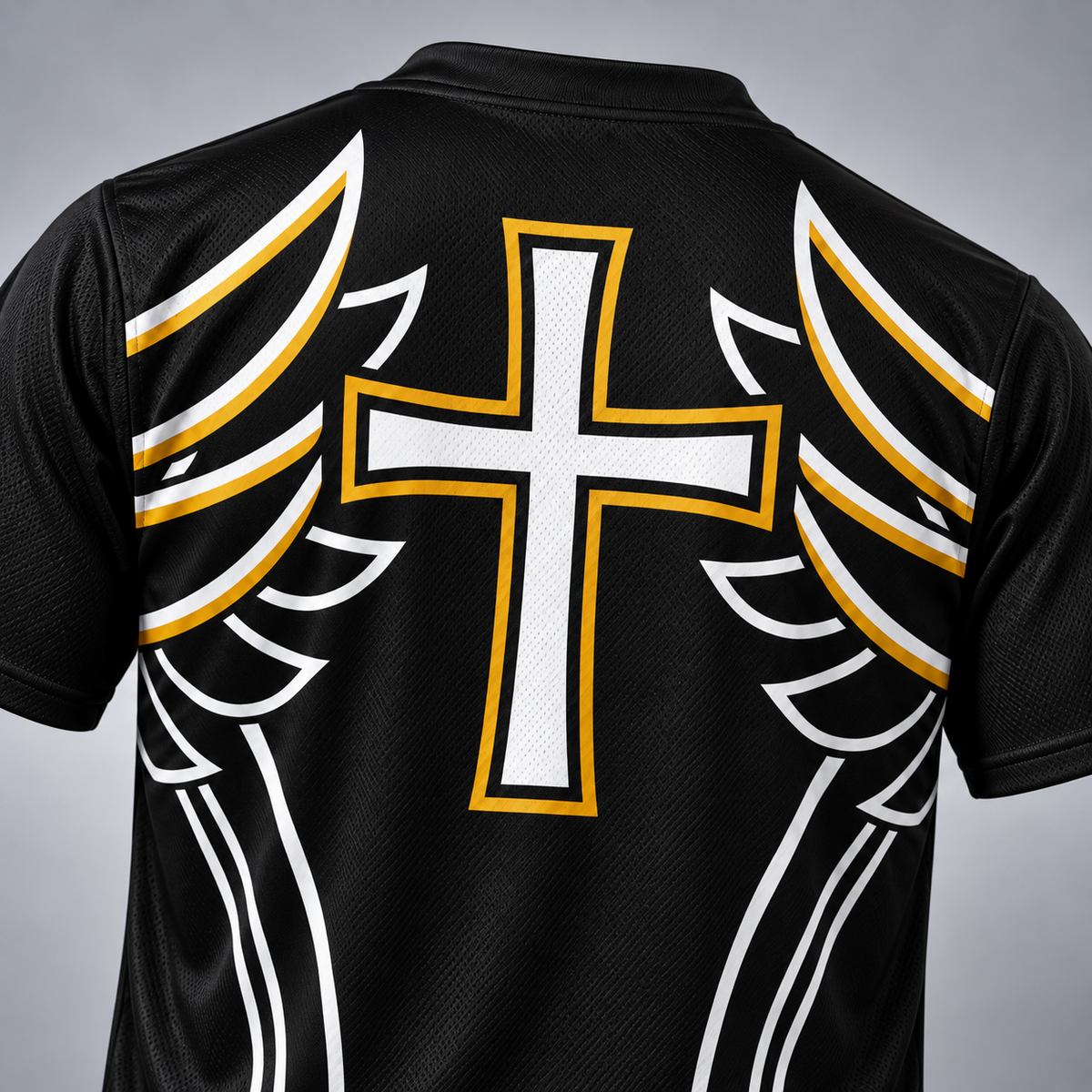Close-up of the back of a black athletic jersey with a large white cross outlined in gold down the center, flanked by white and gold wing-like graphics on both sides.
