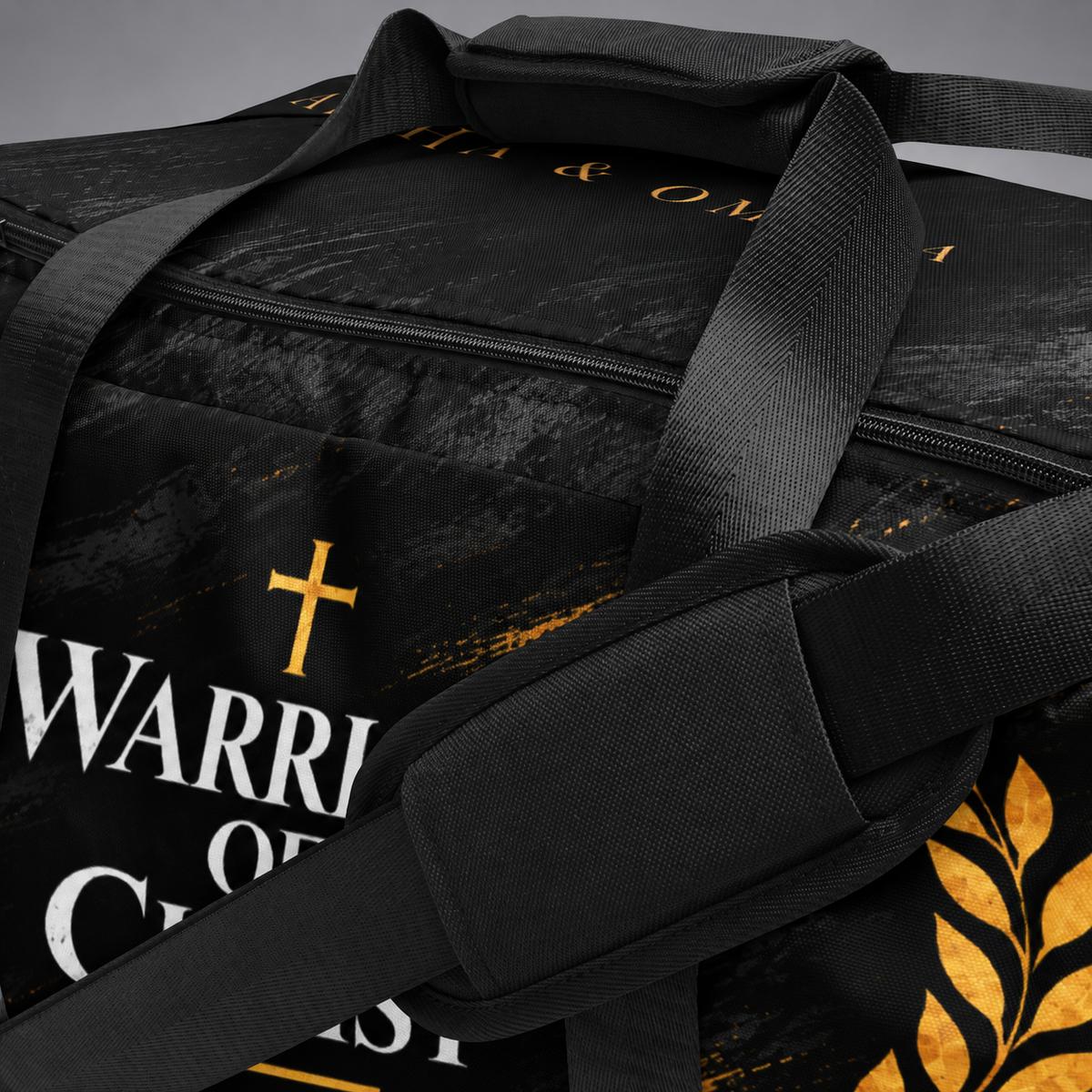 A close-up of a black duffel bag with a distressed texture, featuring a gold cross, white and gold text reading 'WARRIOR OF CHRIST', and a gold laurel leaf design.