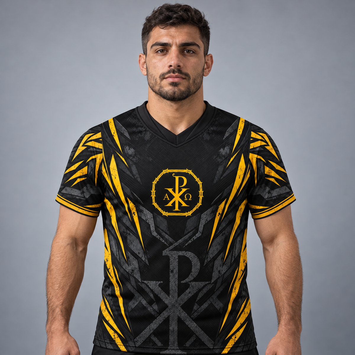 A man wearing a black and yellow athletic jersey with a V-neck, featuring a yellow monogram logo on the chest, set against a solid gray studio background.