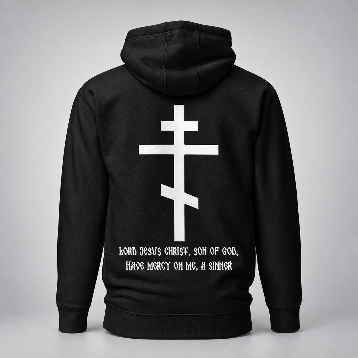 Rückansicht eines schwarzen Hoodies mit großem weißem Kreuzmotiv und weißer Aufschrift „Herr Jesus Christus, Sohn Gottes, erbarme Dich meiner, des Sünders“ vor hellgrauem Studiohintergrund.