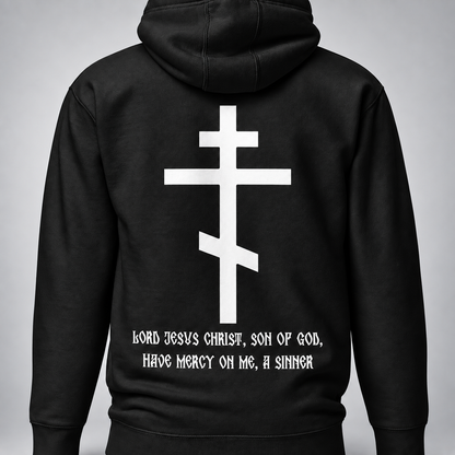 Rückansicht eines schwarzen Pullover-Hoodies mit großem weißem ostorthodoxem Kreuzmotiv und weißer Aufschrift „Herr Jesus Christus, Sohn Gottes, erbarme Dich meiner, des Sünders“ unter dem Kreuz vor hellgrauem Hintergrund.